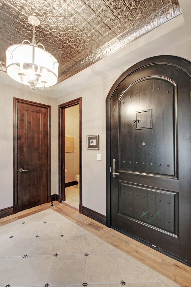 Elegant industrial tin ceiling foyer by a renowned New Home Designer in Calgary.