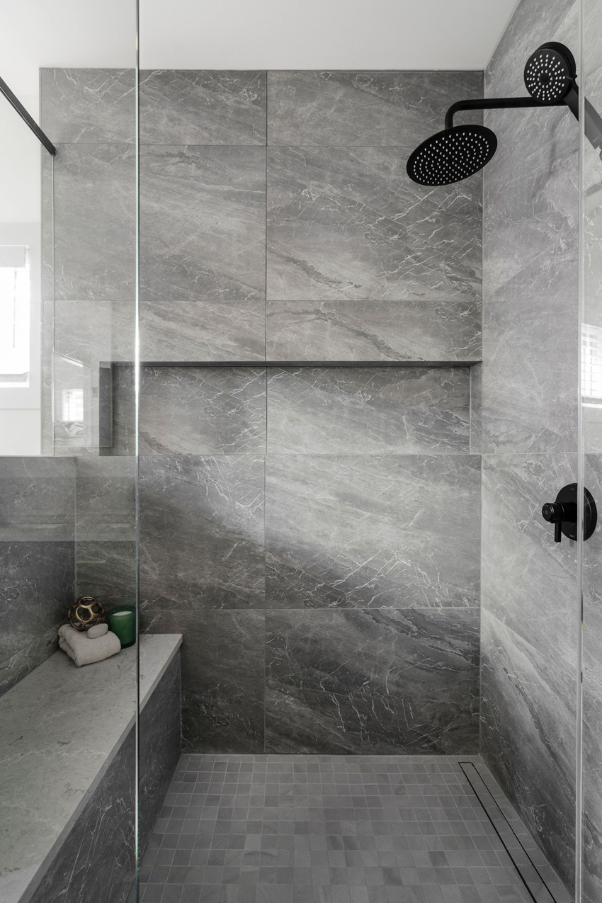 Modern bathroom renovation with gray marble tiles and glass shower enclosure, designed by a top Calgary interior designer.