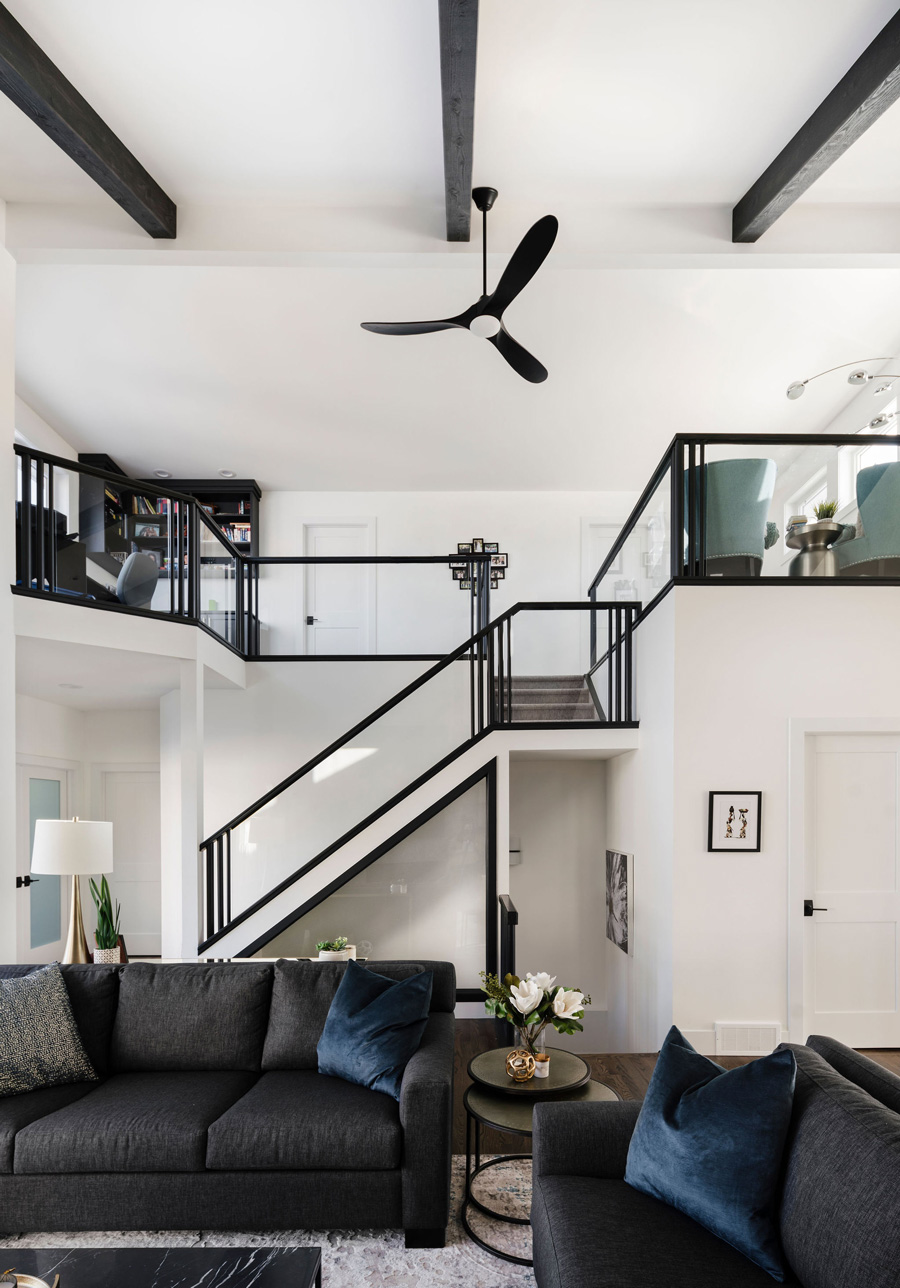 Modern bright renovation with black accents, black stair rail, open concept designed by a top Calgary interior designer.