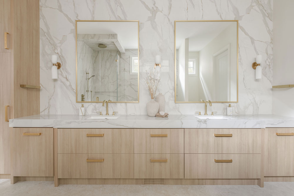 A stylish laundry room featuring floral wallpaper, modern appliances, and encaustic patterned tile flooring undergoes a renovation by a prominent Calgary interior designer.