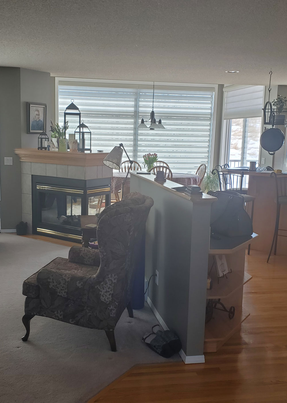 “Before renovation: dated Calgary kitchen with oak cabinetry, laminate countertops, peninsula seating and hanging pot rack.”
